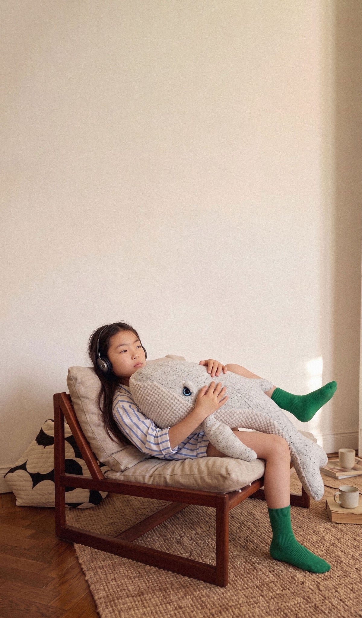Child resting on a giant plush in an armchair